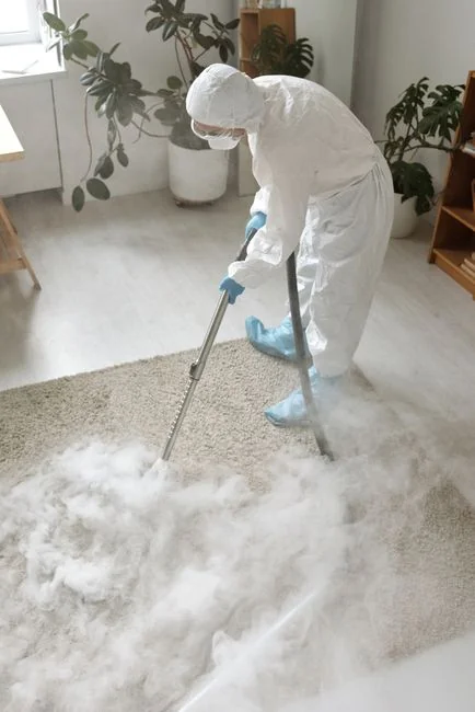 why-choose-us An individual disinfects a workspace using fumigation, wearing full protective gear for safety.